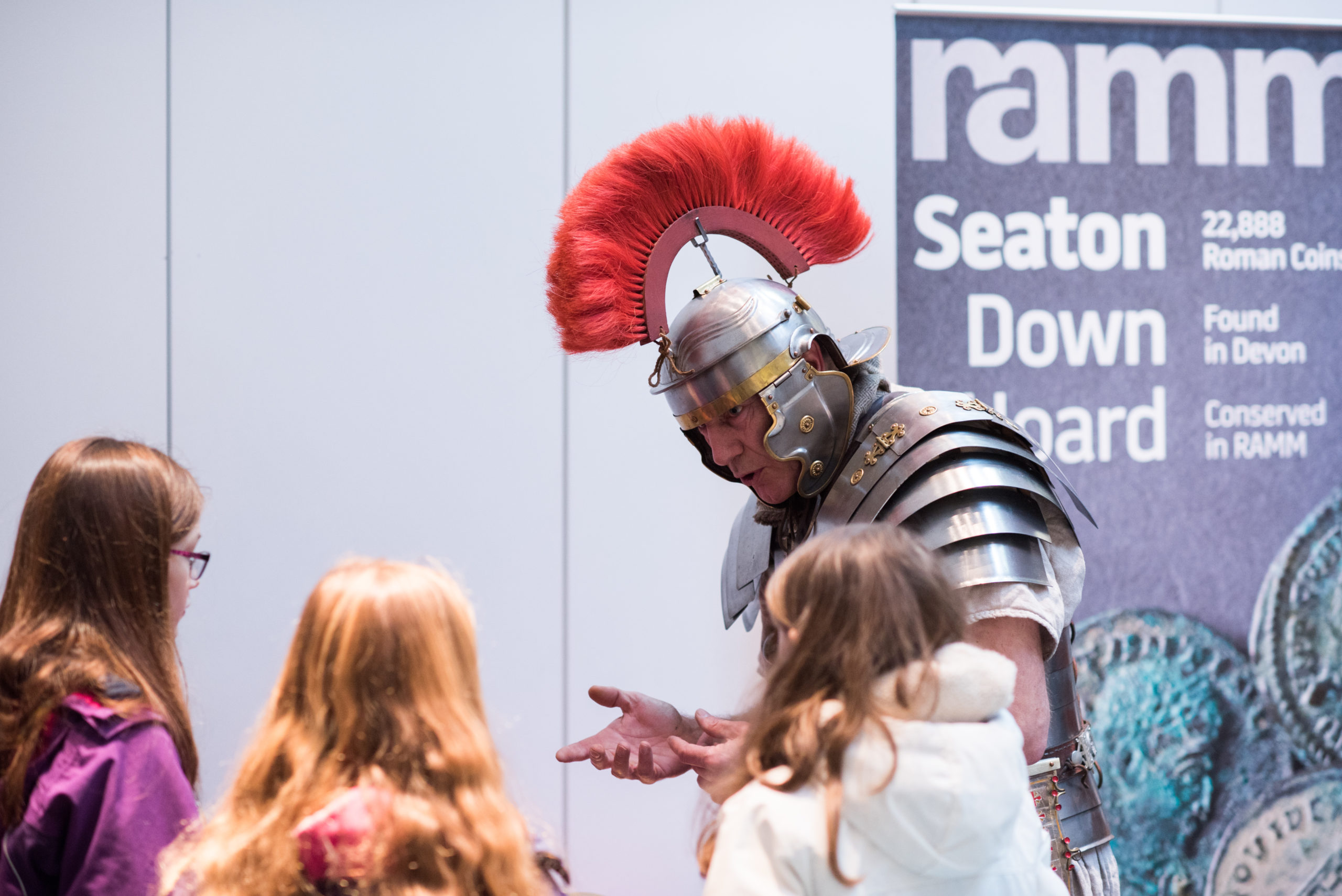 An actor dressed as a Roman Centurion speaks to school children