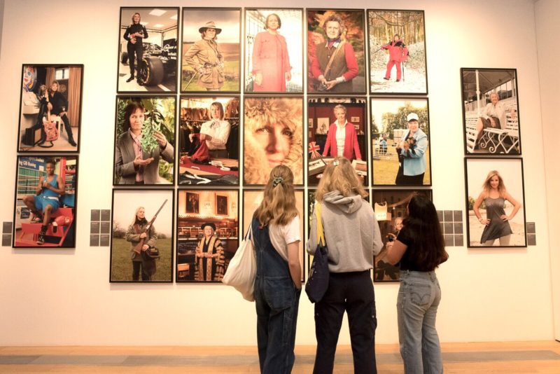 Three students enjoy Anita Corbin's 100 First Women exhibition