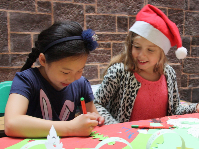 two young girls making Christmas crafts