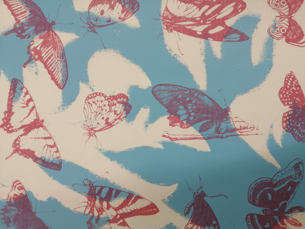 A print of red butterflies and moths on a blue and white background