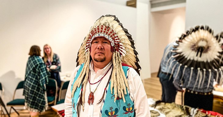 Siksika Councillor Kent Ayoungman wearing tribal headdress at RAMM