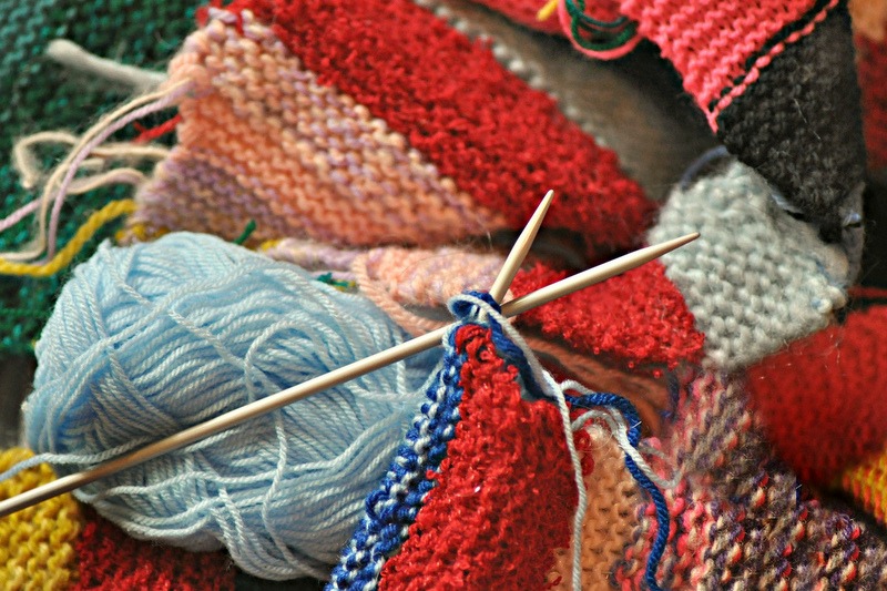 variegated colours of knitting material populate the frame
