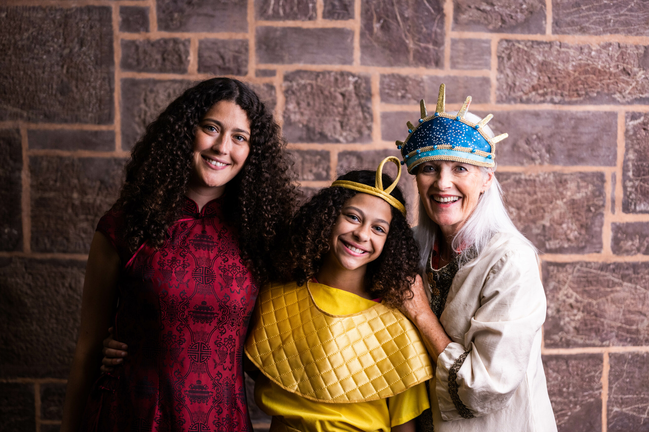 Image of an older lady with two younger ladies dressing up in fancy dress costumes