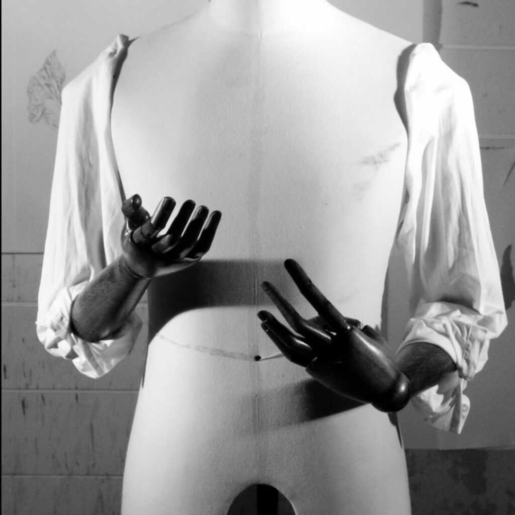 Naomi Frears, Trello, 2021, black and white sculpture with model hands and sleeves.