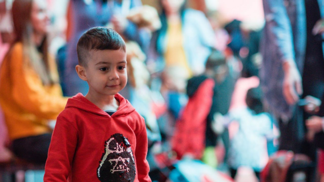 Small boy standing in the museum smiling at the camera.